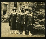 Four graduates posing on Front Campus
